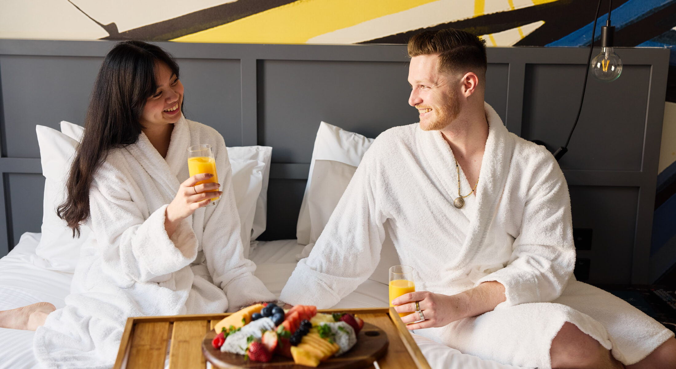 Couple in bed, enjoying romantic getaway Darling Harbour