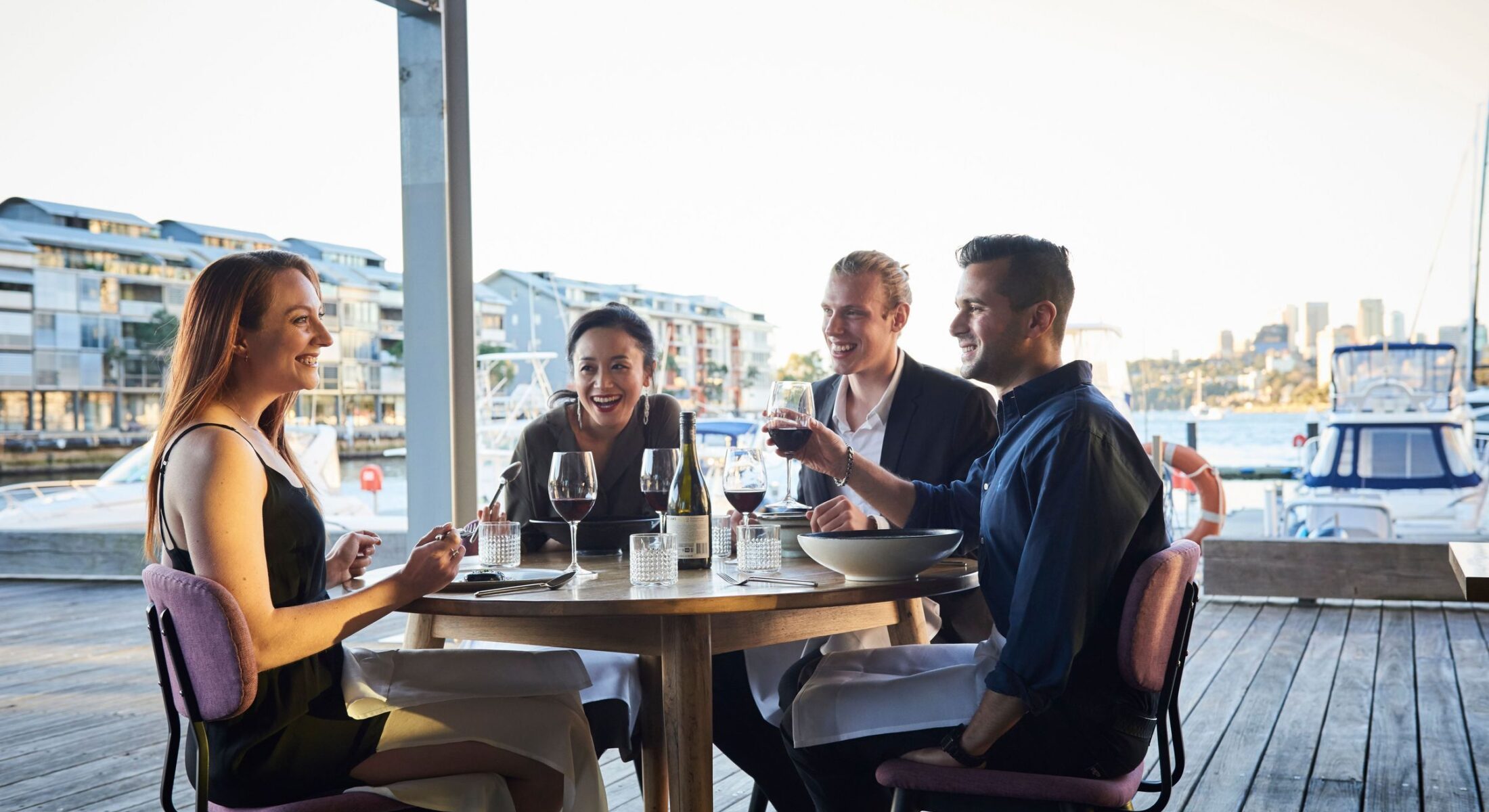 Friends enjoying food and drink at waterside restaurant LuMi Bar & Dining, Pyrmont.