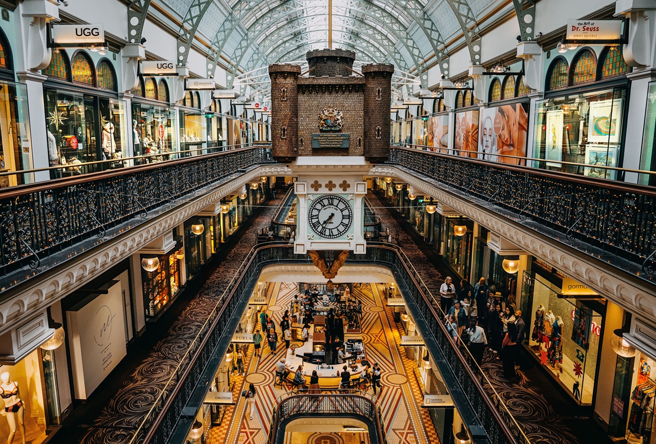 QVB History Tour participants in the main atrium, looking at the Royal Clock and historic shopfronts.