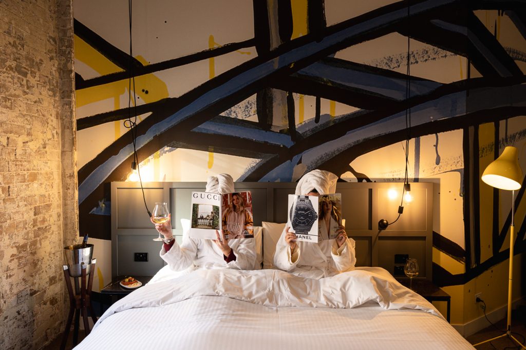 Two girls reading magazines in bed